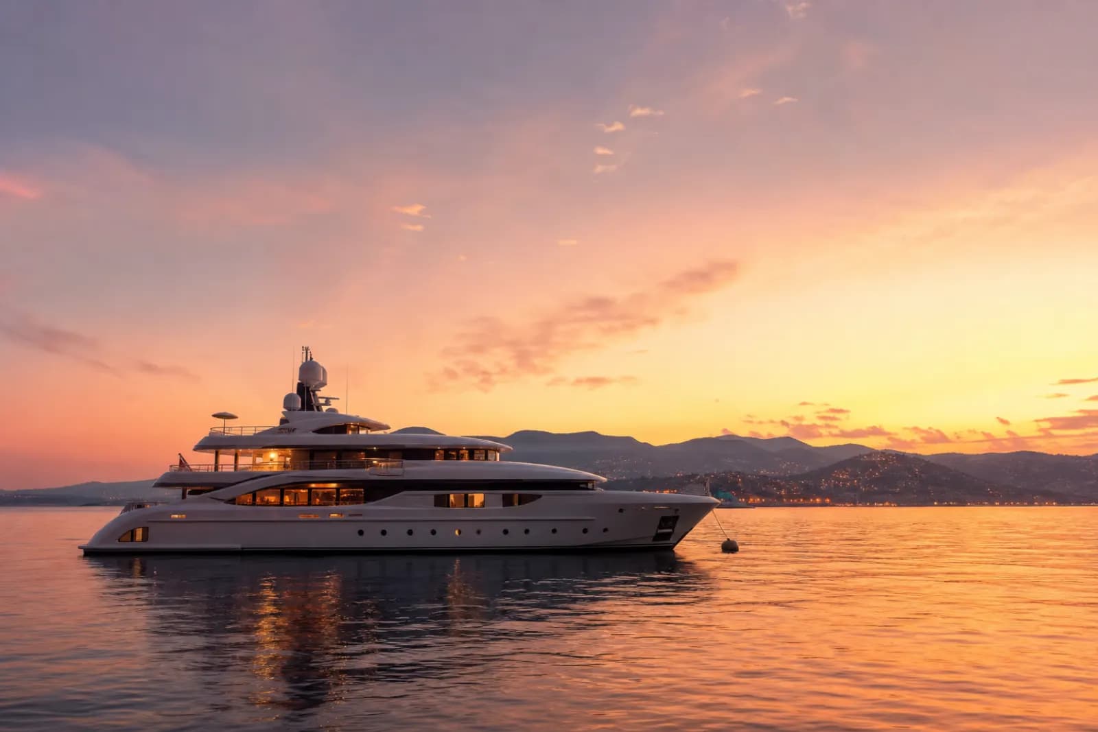 Costa Brava yacht charter at sunset with a superyacht